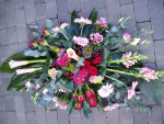 rouwbloemstuk in de rood/roze tinten