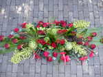 Rouwbloemstuk rood gegroepeerd