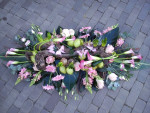 rouwbloemstuk in de roze tinten met vlinders