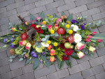 rouwbloemstuk in bonte kleuren
